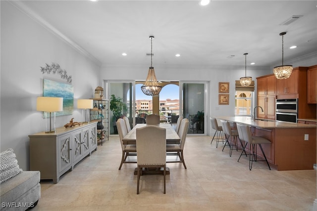 dining area with an inviting chandelier, ornamental molding, and sink