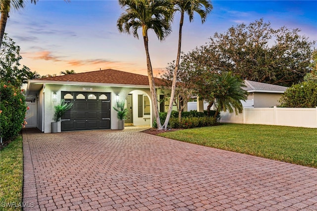 view of front of home featuring a garage and a lawn