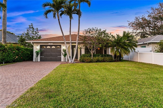 ranch-style house featuring a yard and a garage