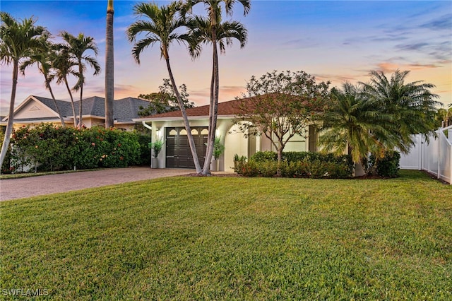 view of front of home with a garage and a yard