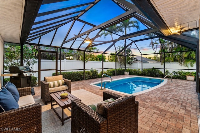 pool at dusk featuring an outdoor living space, a patio, a lanai, and grilling area