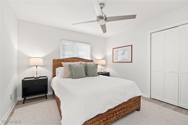 bedroom with ceiling fan, light hardwood / wood-style floors, and a closet