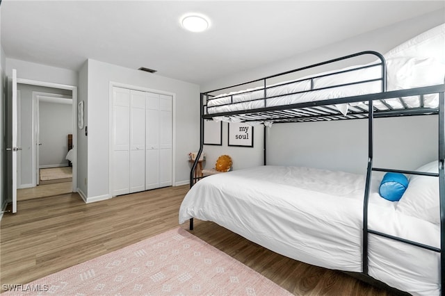 bedroom with light wood-type flooring and a closet