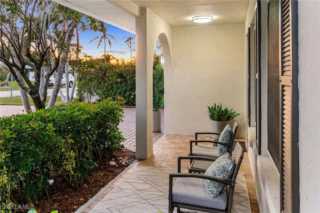 patio terrace at dusk featuring a porch