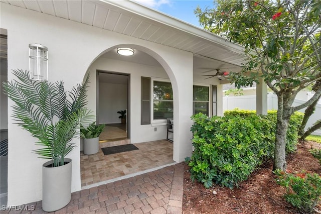 view of exterior entry featuring a patio and ceiling fan