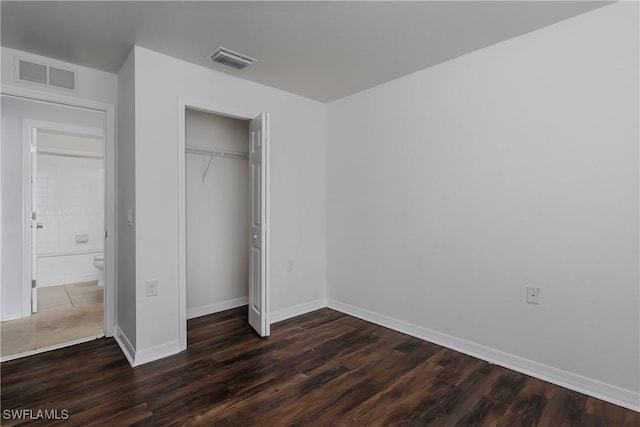 unfurnished bedroom featuring dark wood-type flooring and a closet