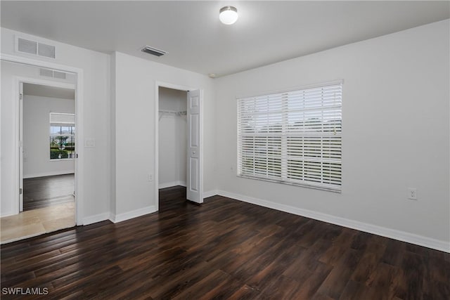 unfurnished bedroom with dark hardwood / wood-style floors and a closet