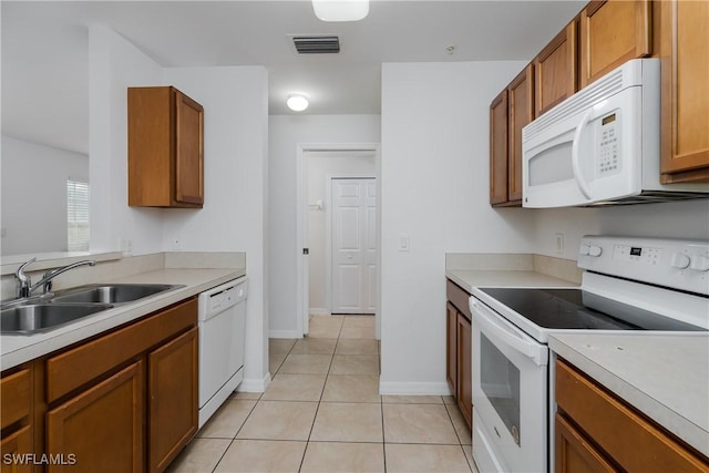 kitchen with sink, white appliances, and light tile patterned floors