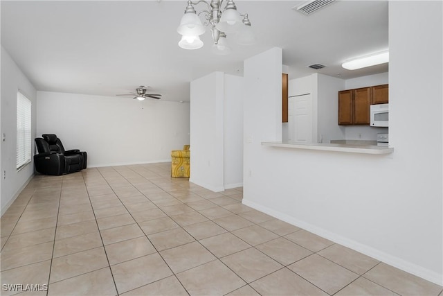 unfurnished living room with ceiling fan with notable chandelier and light tile patterned floors