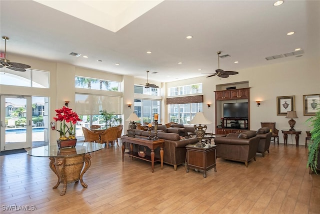 living room with french doors, ceiling fan, light hardwood / wood-style flooring, and a wealth of natural light