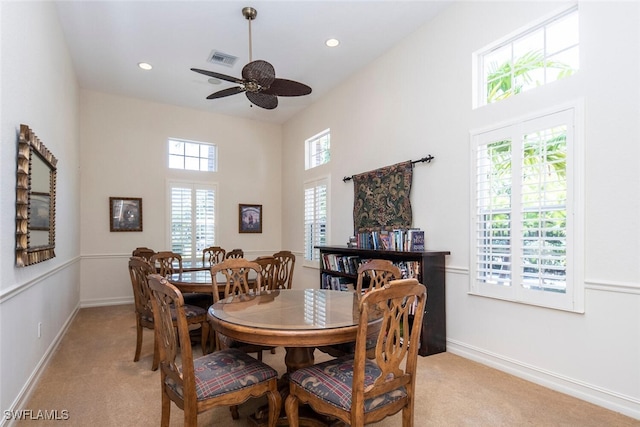 carpeted dining area with ceiling fan