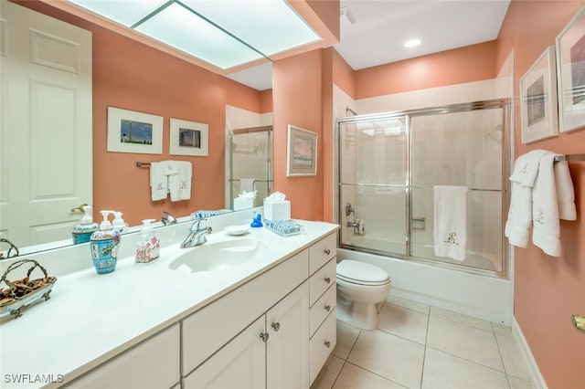 full bathroom featuring toilet, shower / bath combination with glass door, a skylight, vanity, and tile patterned flooring