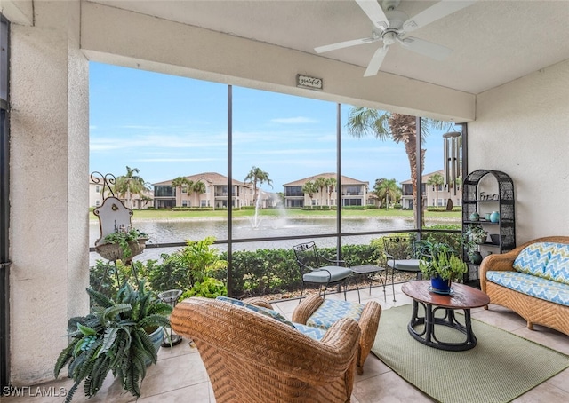 sunroom / solarium featuring ceiling fan and a water view