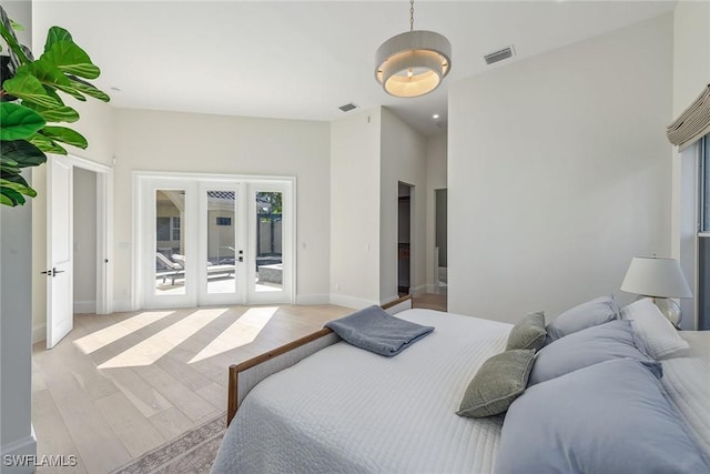 bedroom with light hardwood / wood-style floors, access to outside, and french doors