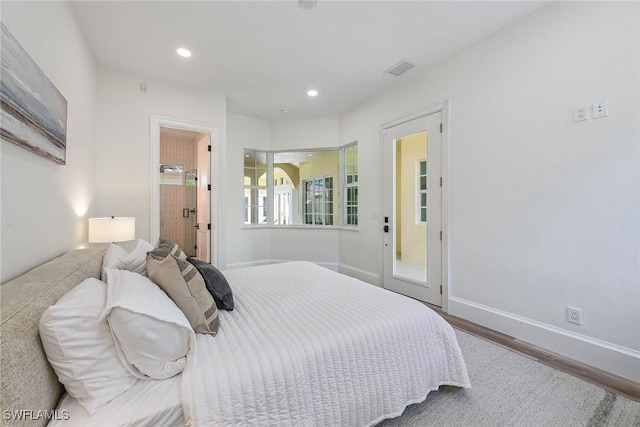 bedroom featuring ensuite bathroom and wood-type flooring