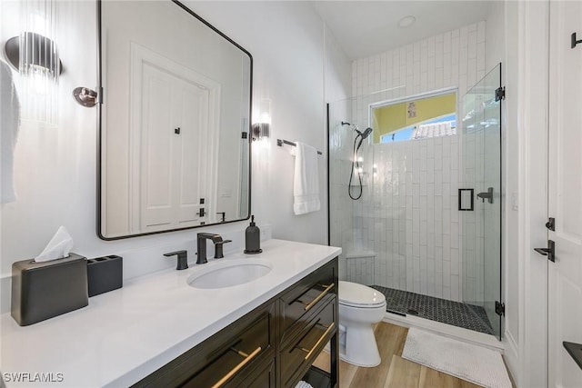 bathroom featuring walk in shower, vanity, toilet, and hardwood / wood-style flooring