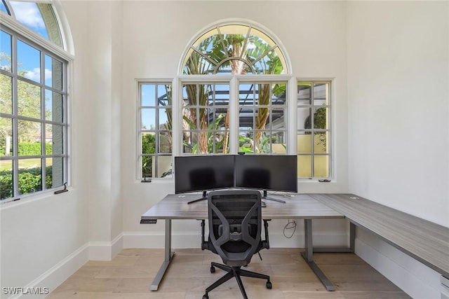 home office with light hardwood / wood-style flooring