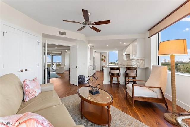 living room with ceiling fan, sink, and dark hardwood / wood-style flooring