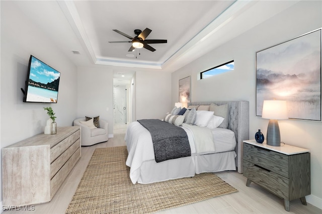 bedroom with ceiling fan and a raised ceiling