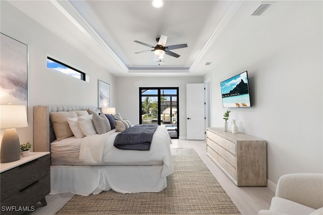 bedroom featuring a tray ceiling, access to exterior, crown molding, and ceiling fan