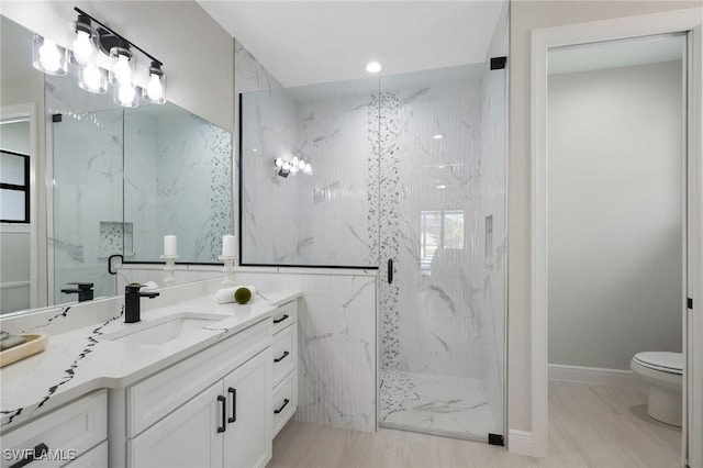 bathroom featuring toilet, vanity, and an enclosed shower