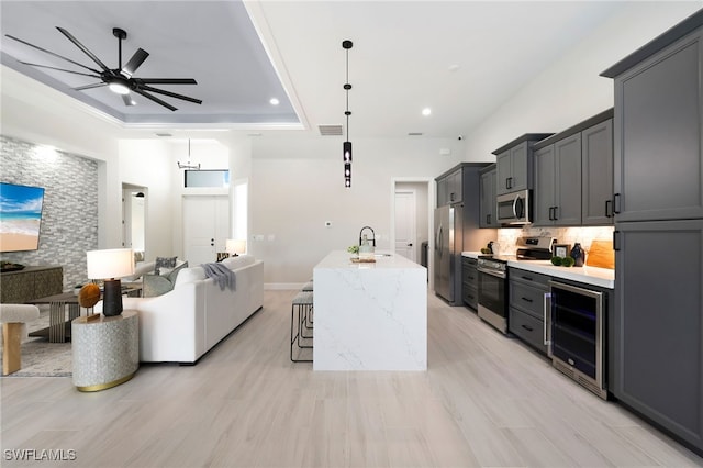 kitchen with appliances with stainless steel finishes, a kitchen bar, wine cooler, and decorative light fixtures