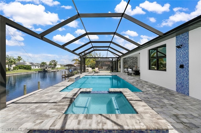 view of swimming pool with a patio area, a water view, an in ground hot tub, and glass enclosure