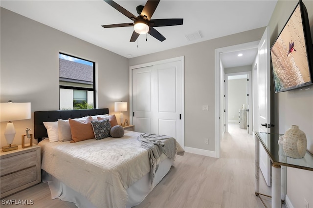 bedroom featuring ceiling fan, light hardwood / wood-style floors, and a closet