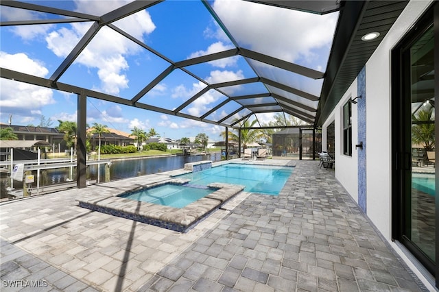 view of pool with an in ground hot tub, a water view, a lanai, and a patio area