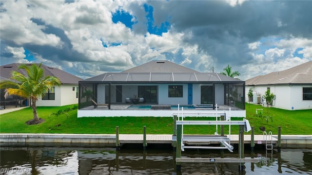 back of house with a patio area, a yard, a lanai, and a water view