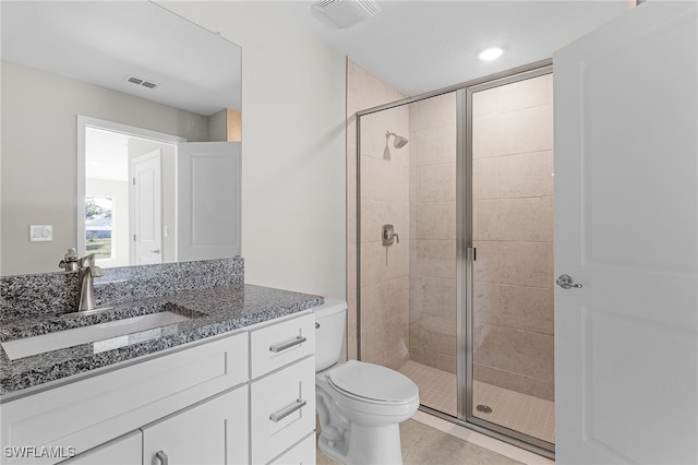 bathroom with a shower with door, tile patterned floors, toilet, and vanity