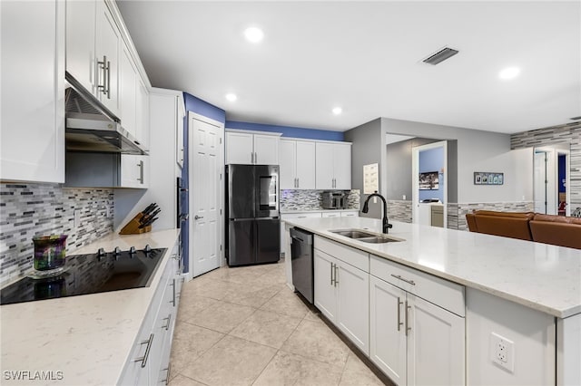 kitchen with fridge, black electric cooktop, white cabinets, sink, and backsplash