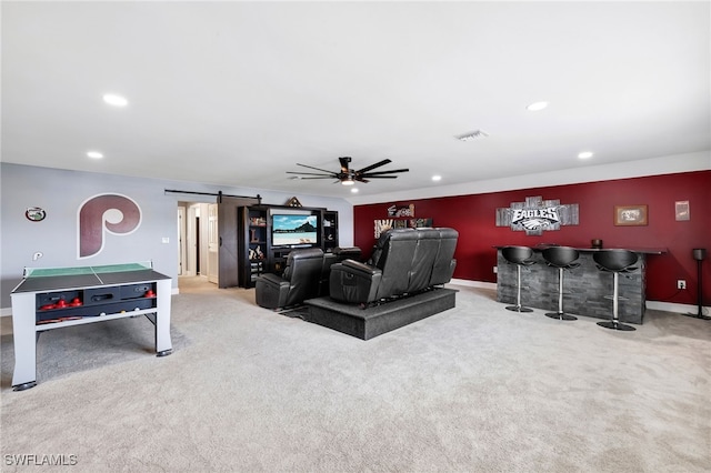 interior space with indoor bar, light colored carpet, ceiling fan, and a barn door