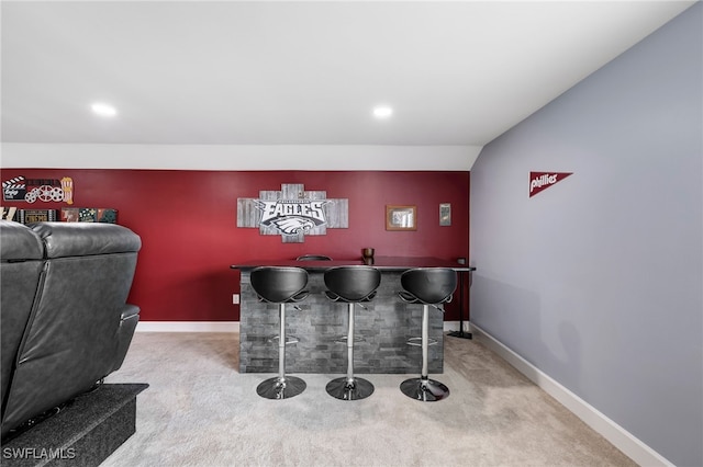 bar with lofted ceiling and carpet flooring