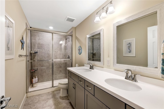 bathroom featuring a shower with shower door, toilet, and vanity