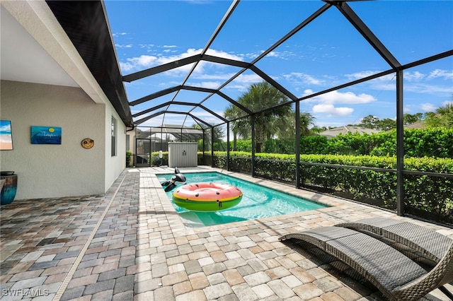 view of pool featuring glass enclosure and a patio area