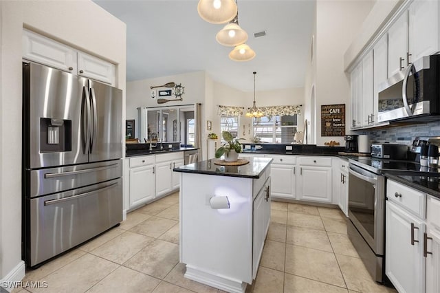 kitchen with light tile patterned flooring, white cabinetry, a center island, appliances with stainless steel finishes, and pendant lighting