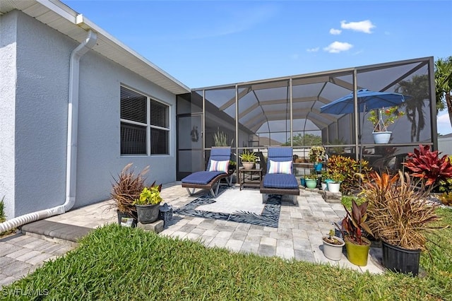 view of patio featuring glass enclosure