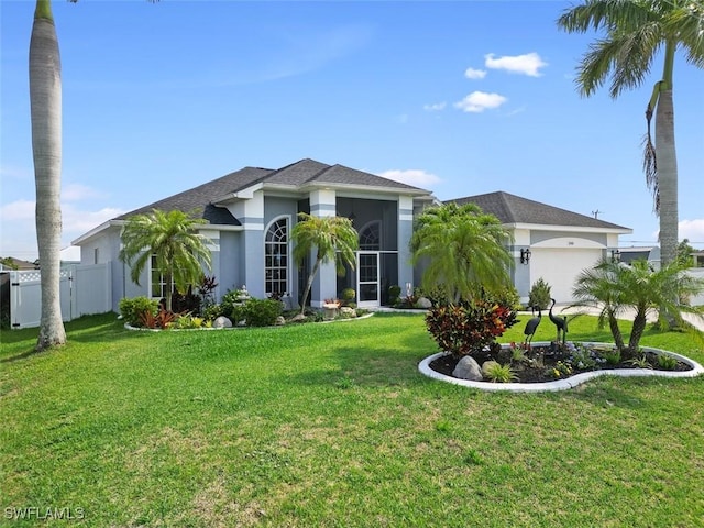 view of front of house with a garage, a sunroom, and a front lawn