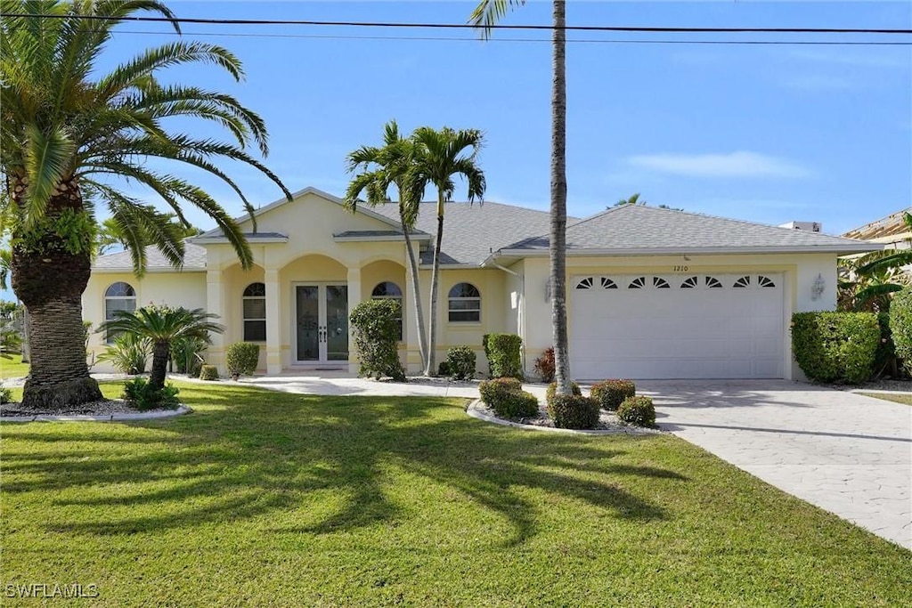 view of front of house with french doors, a garage, and a front lawn