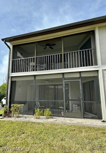 rear view of property with a yard and a sunroom