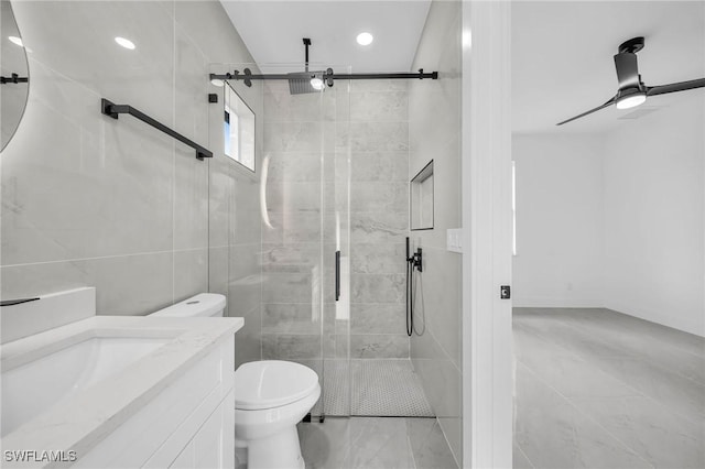 bathroom featuring toilet, ceiling fan, a shower with shower door, and vanity