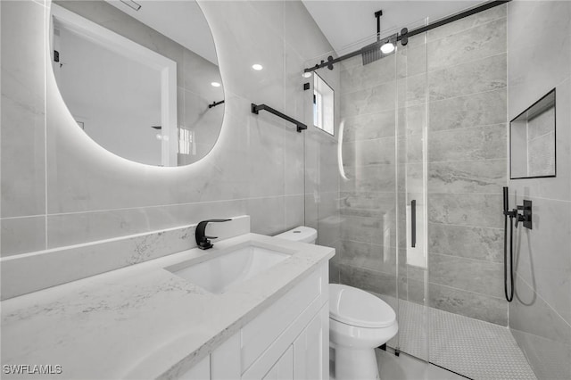 bathroom featuring toilet, a shower with door, and vanity