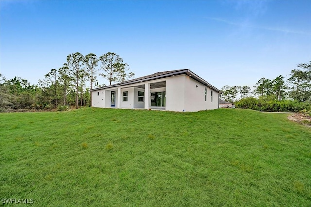 rear view of property featuring a lawn