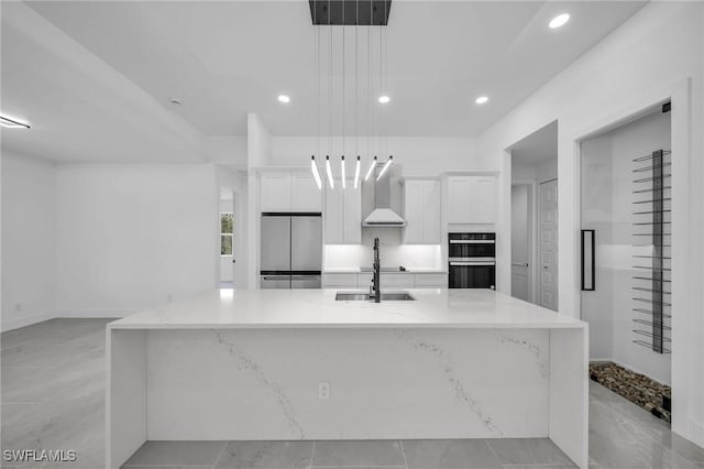 kitchen with decorative light fixtures, a spacious island, stainless steel refrigerator, white cabinets, and wall chimney exhaust hood