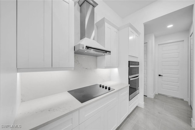 kitchen featuring white cabinets, wall chimney exhaust hood, double oven, decorative backsplash, and black electric cooktop