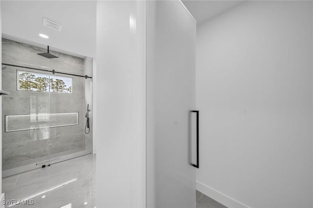 bathroom with an enclosed shower and tile patterned floors