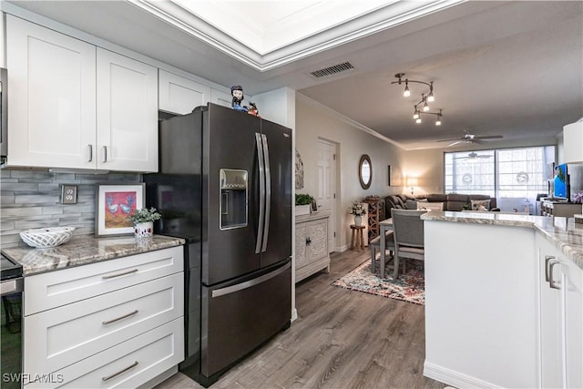 kitchen with white cabinetry, wood-type flooring, ornamental molding, decorative backsplash, and black fridge with ice dispenser