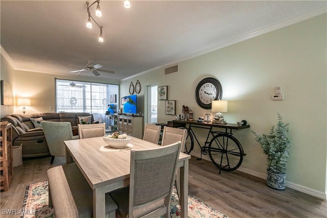 dining space with dark hardwood / wood-style flooring, crown molding, and ceiling fan