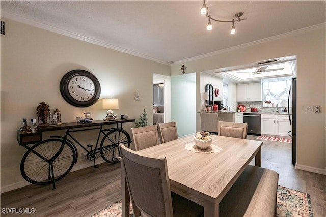 dining area with hardwood / wood-style floors and crown molding